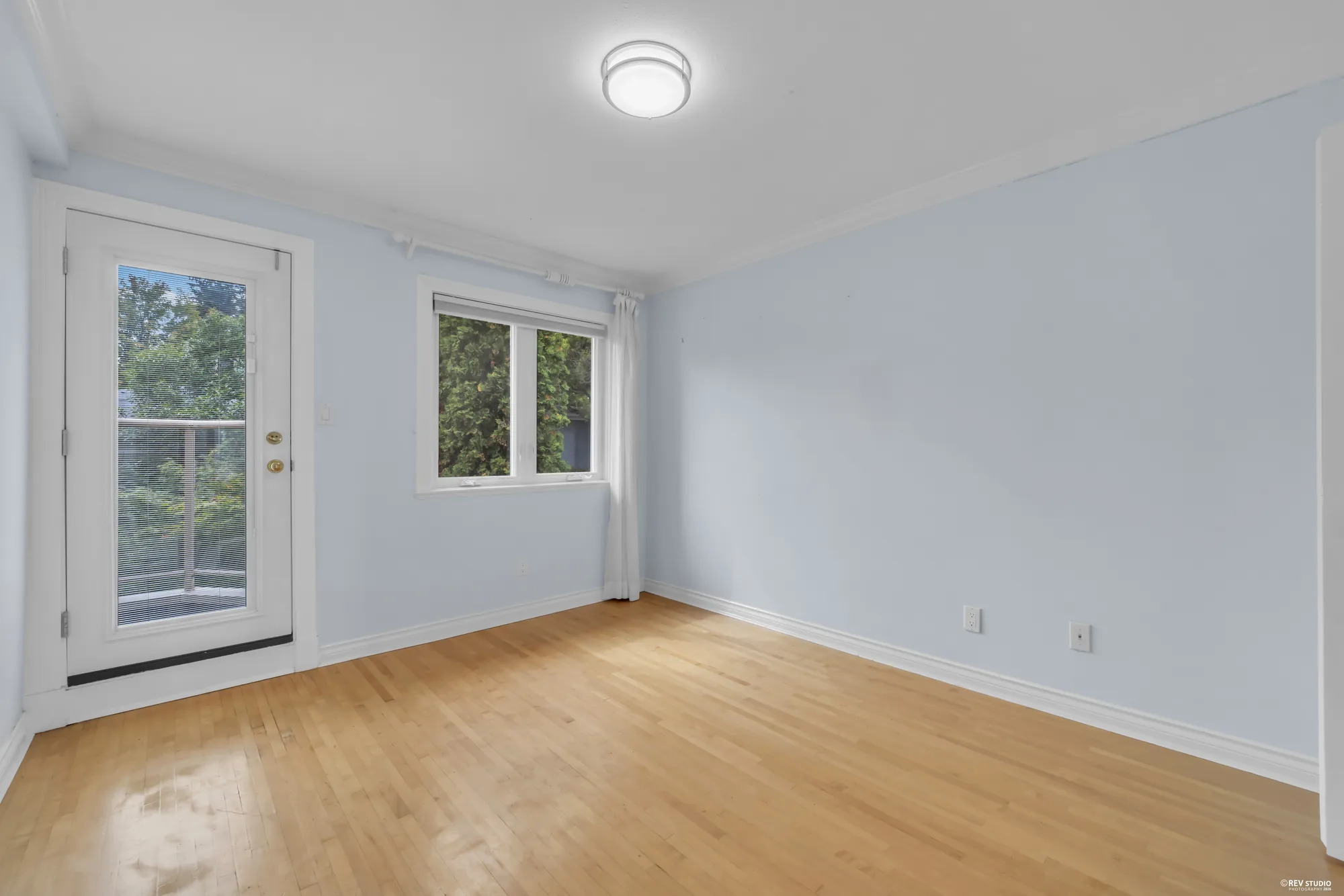 A bedroom with a door to a balcony and a window