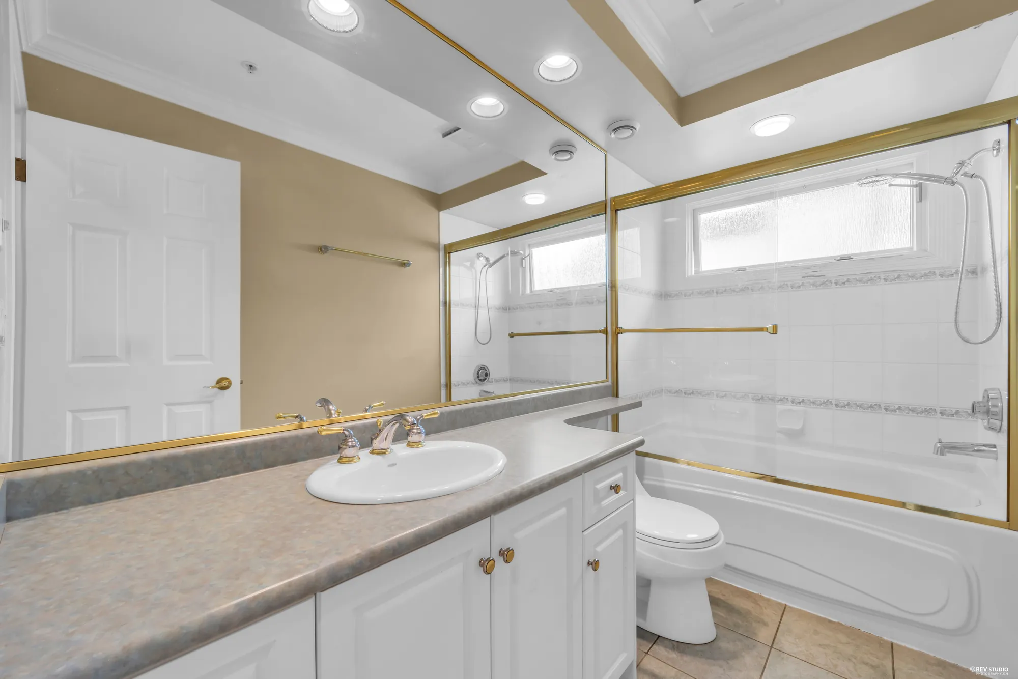 A bathroom with a glass shower and a long vanity