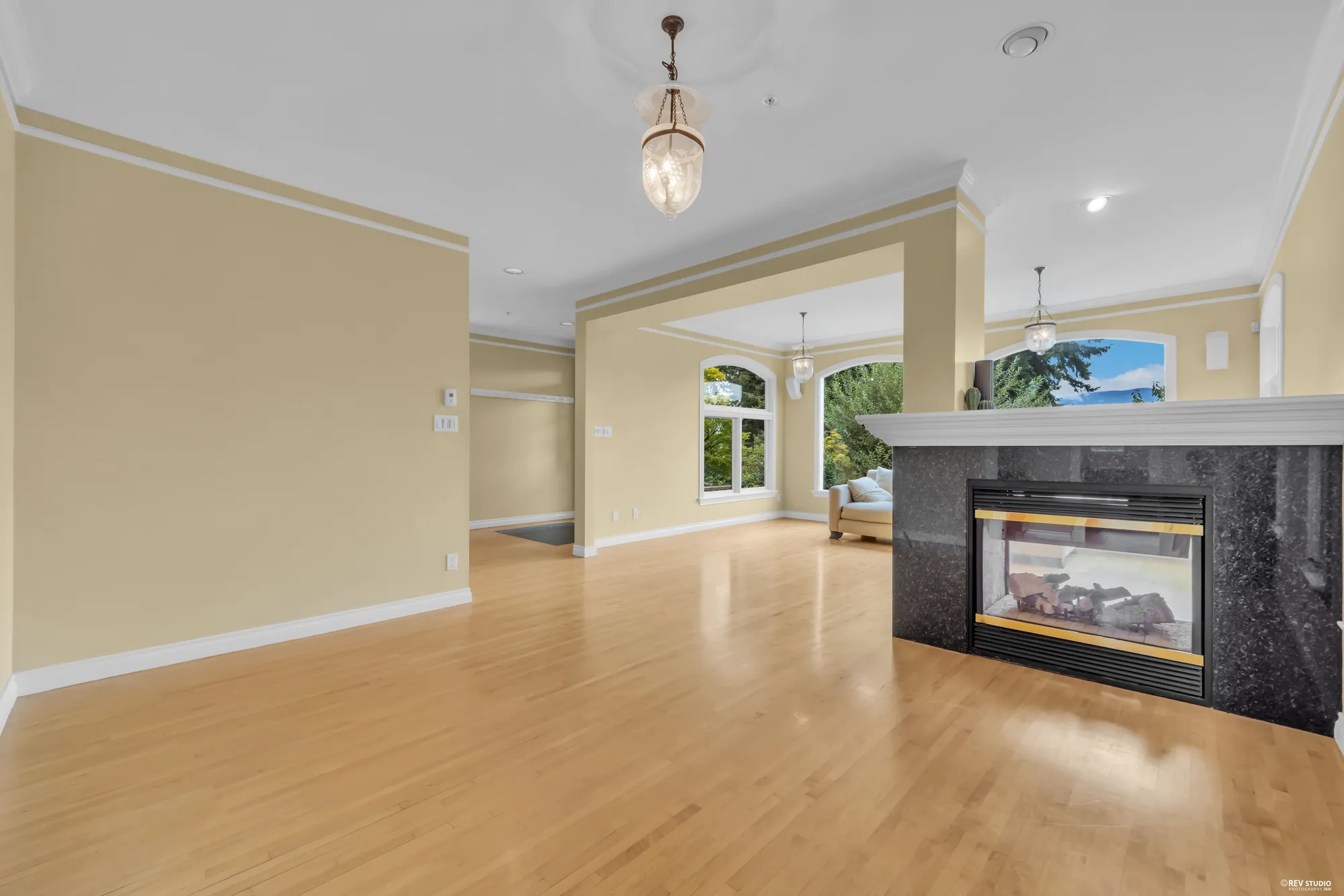 An open room with a fireplace and the hall beyond