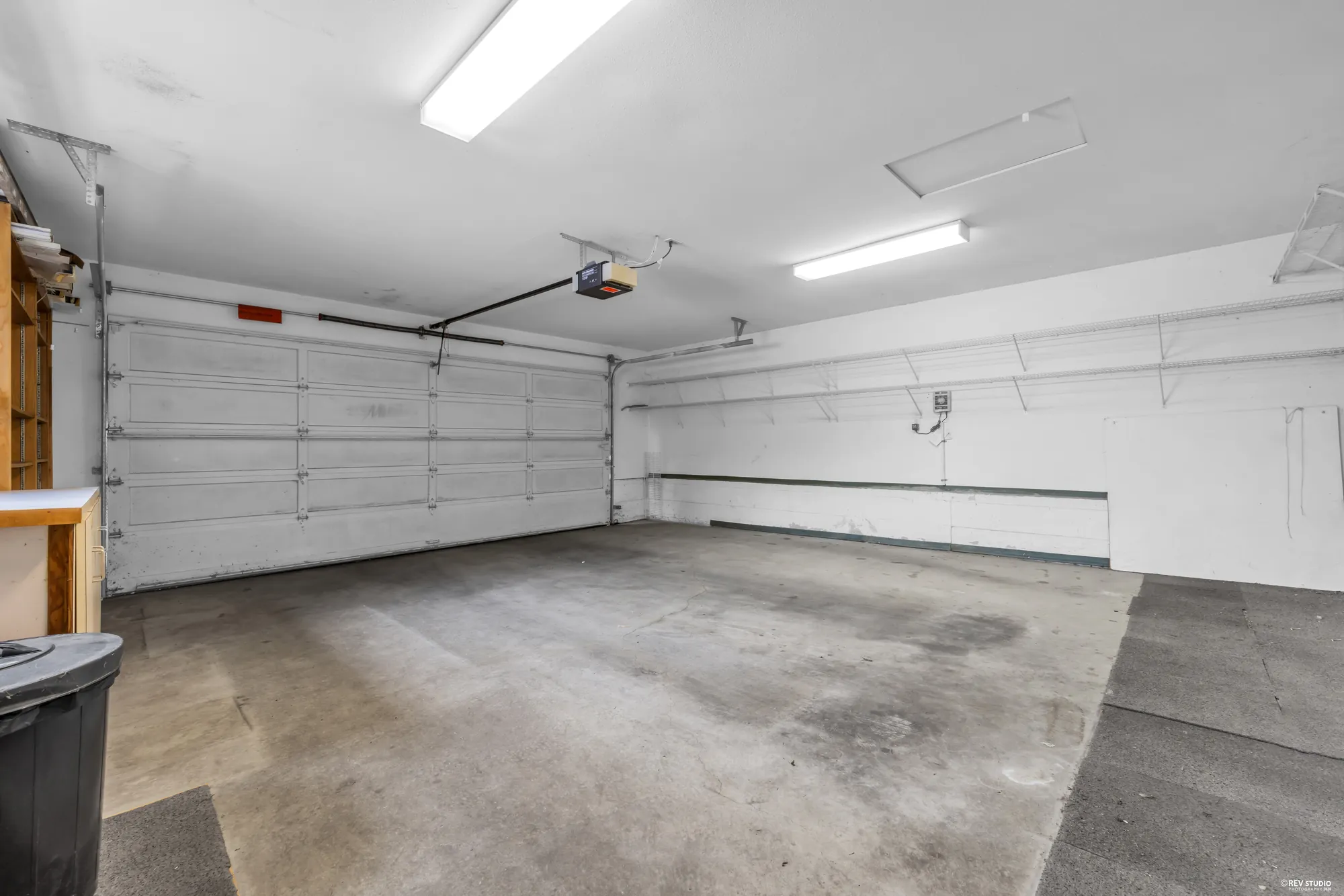 Inside the double garage, empty, with two doors and a side door