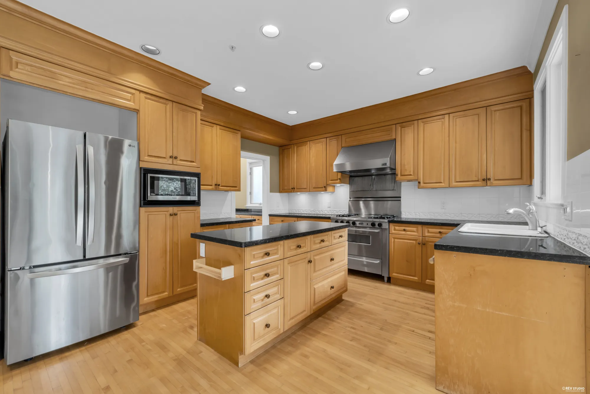 The kitchen from the opposite corner showing the range and refrigerator