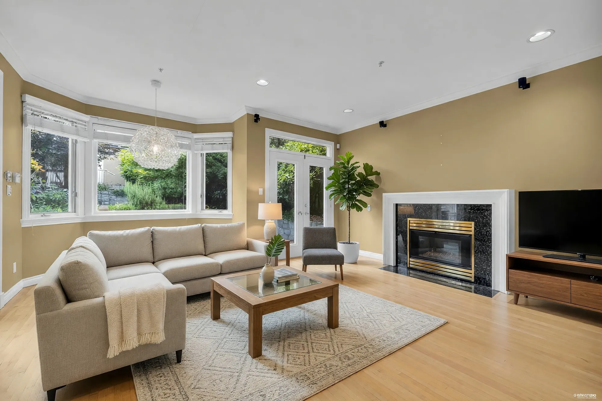 The living room with a fireplace and bay windows, shown with digitally added furniture