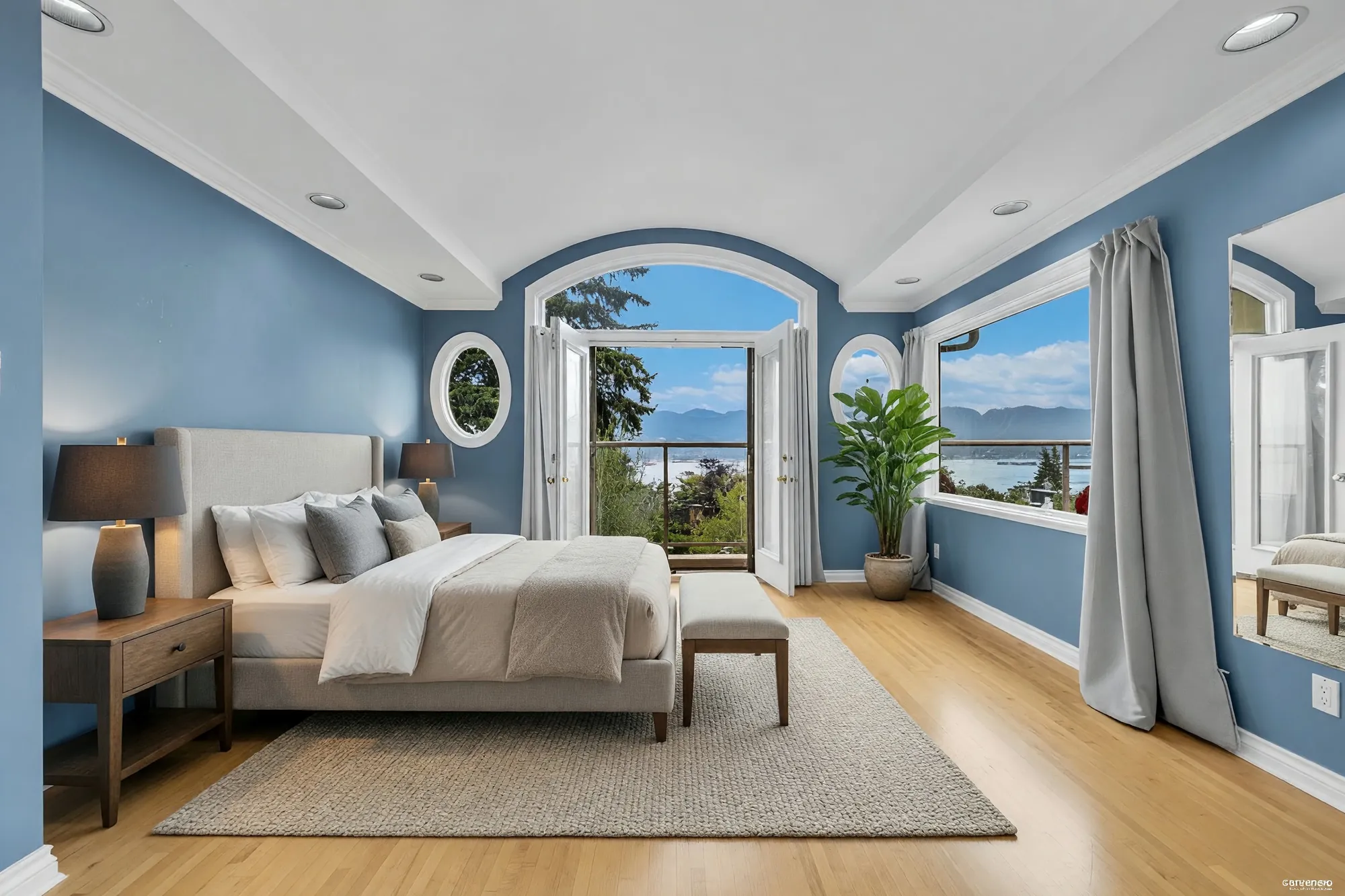 The primary bedroom with blue walls and an arched door to a balcony, shown with digitally added furniture