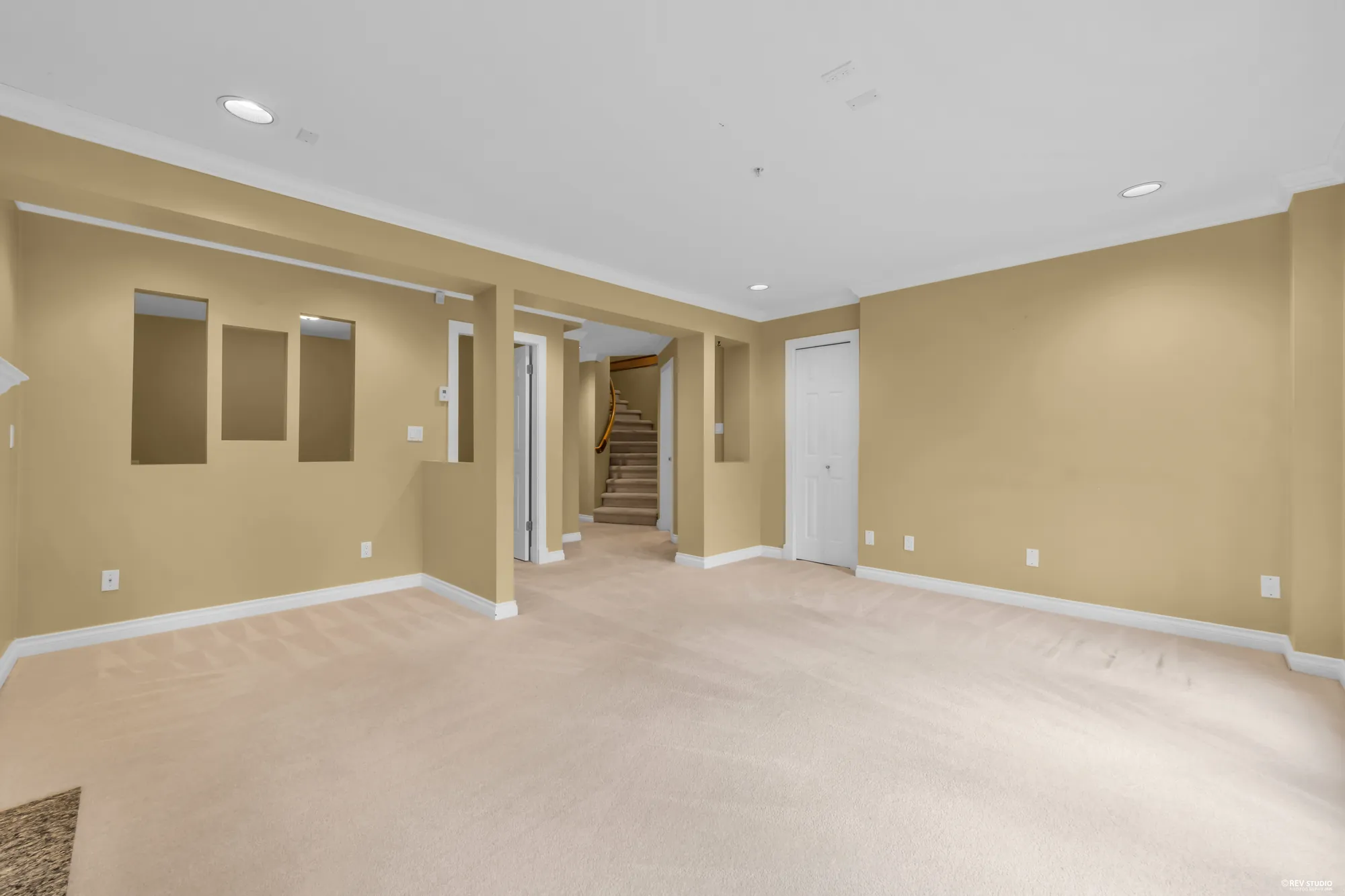 The lower level looking toward the stair, carpeted and empty