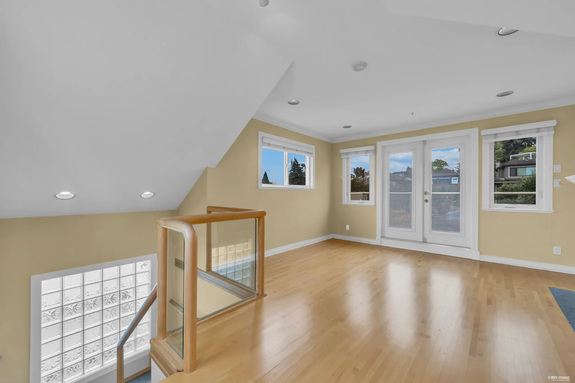 The top floor room as photographed, with dormer windows and a stair rail