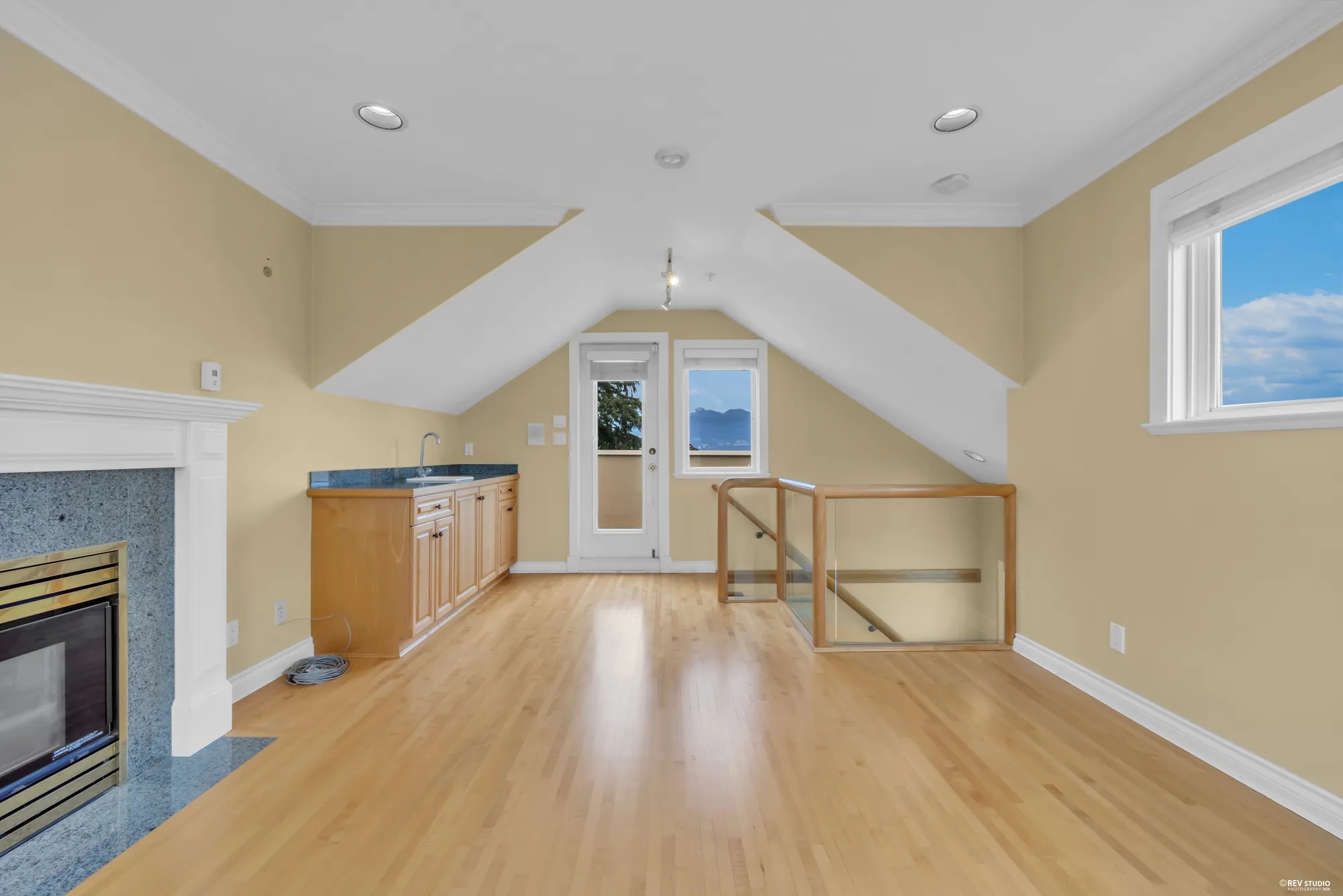 The top floor with a fireplace and a sloped ceiling
