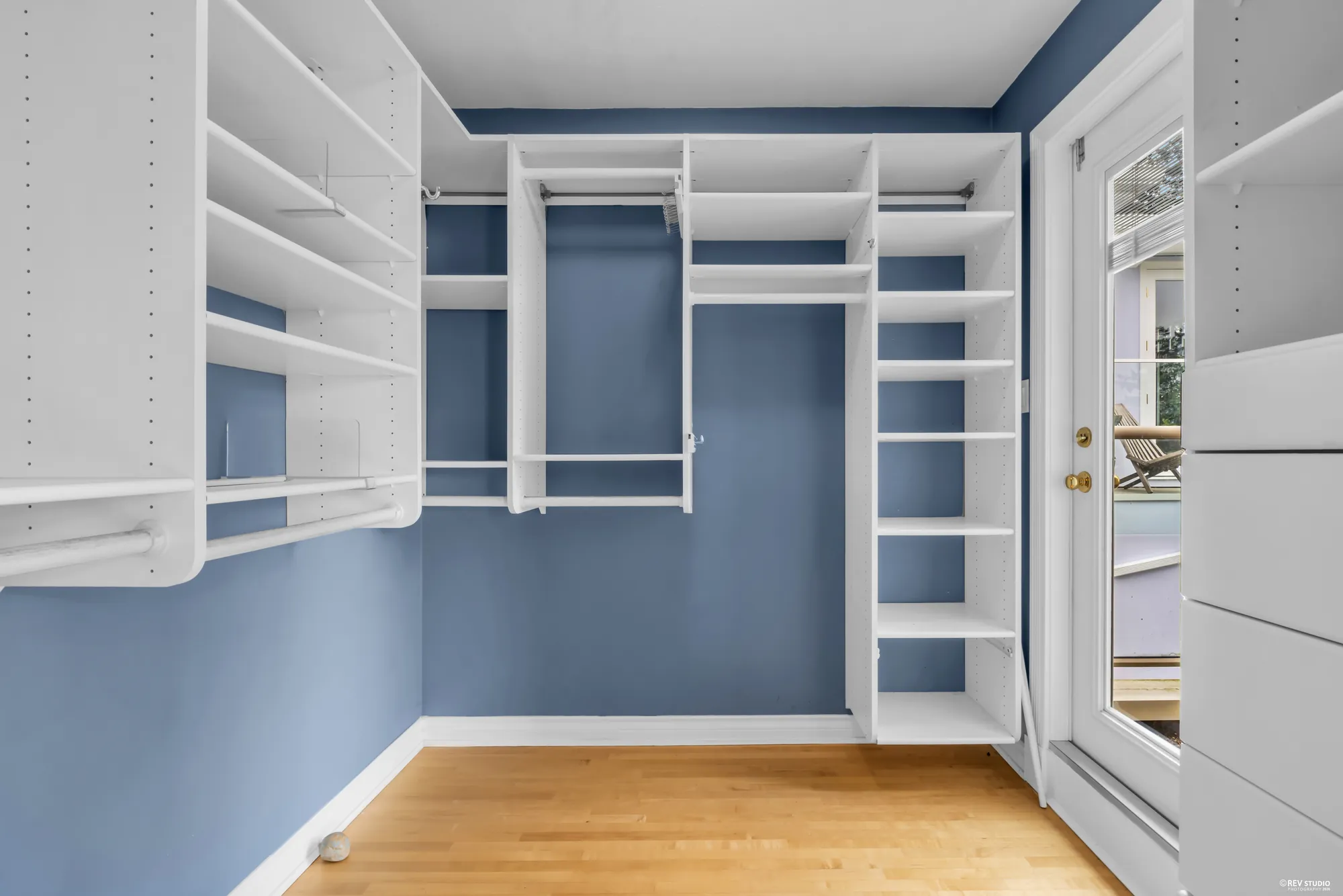 The walk-in closet fitted with shelving and hanging rails